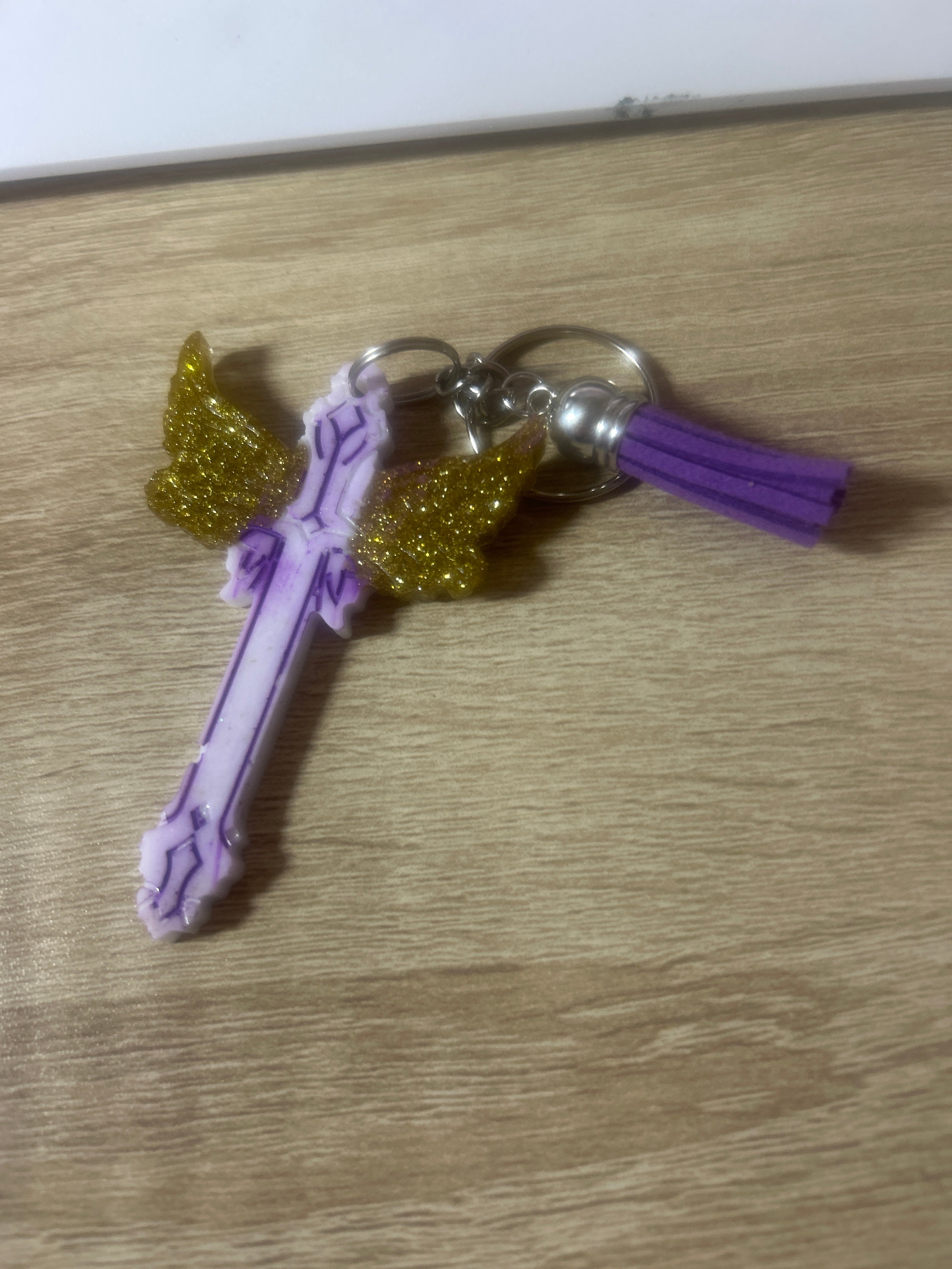 Purple resin cross keychain with gold glitter angel wings and purple tassel