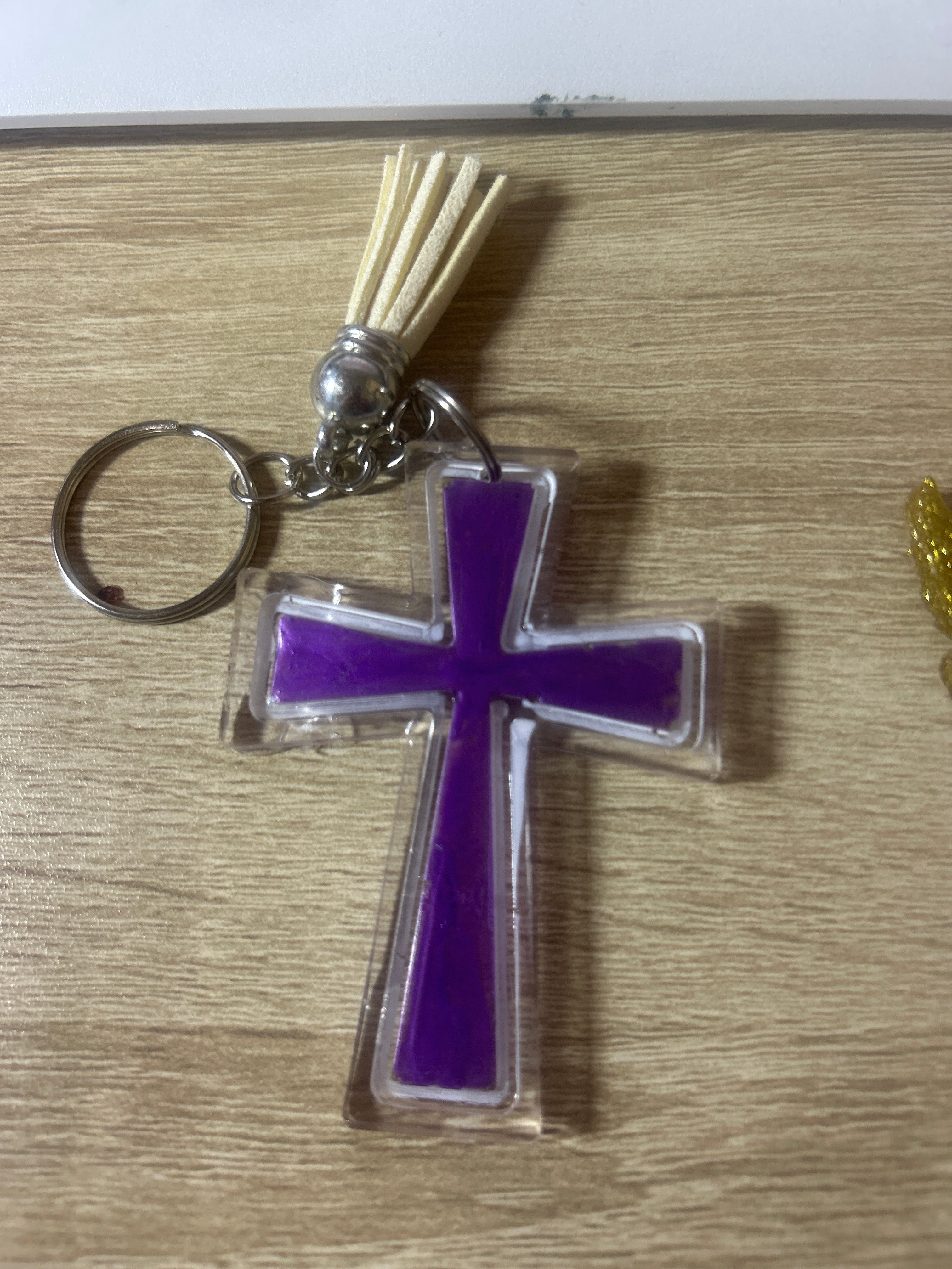 Clear acrylic cross keychain with purple resin inlay, cream tassel and silver ring